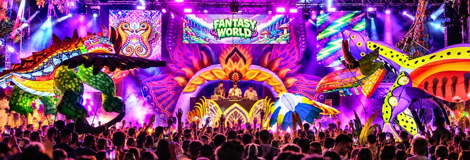 Escenario Fantasy World: arco floral hinchable, animales gigantes iluminados y público con las manos arriba