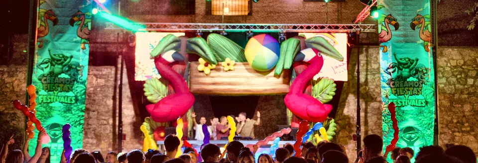 Escenario Flip Flow: flamencos hinchables, palmeras y pelota de playa sobre la cabina de DJ