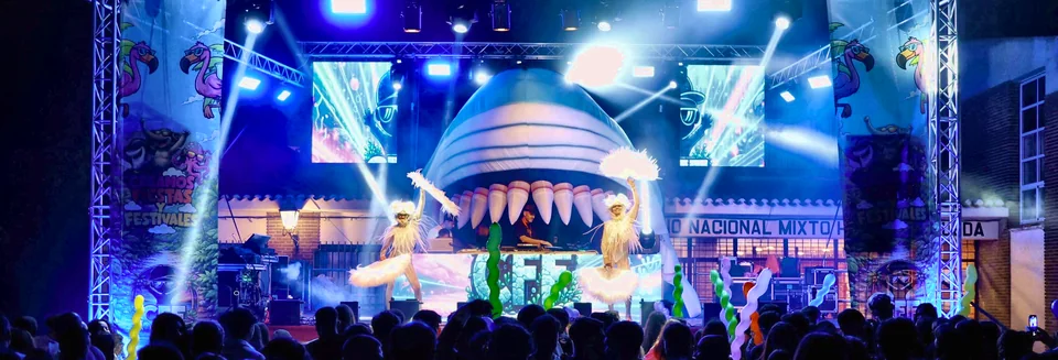 Escenario Shark Party: tiburón hinchable con la boca abierta sobre la cabina y bailarinas en el escenario